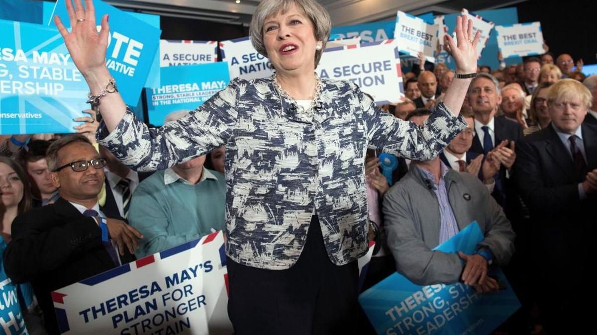 Britain's Prime Minister Theresa May, center, gestures Wednesday at a rally while on the general election campaign trail, in Birmingham, England. Voters were asked to choose: Who is best to keep the U.K. safe?