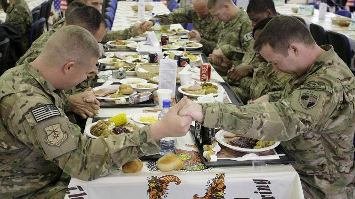 File from Nov. 22, 2012 | U.S. soldiers pray before eating a Thanksgiving meal at a dining hall at the U.S.-led coalition base in Kabul.