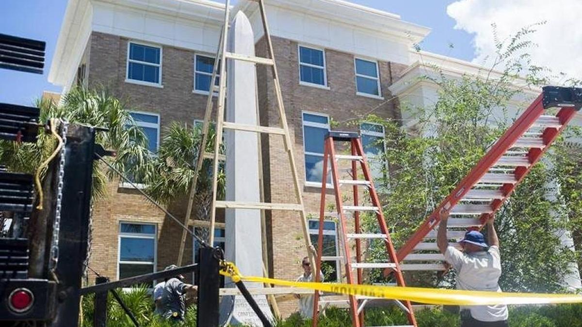 FILE: Workers cover the Confederate Monument outside of the Manatee County Historic Courthouse on Saturday afternoon in downtown Bradenton.