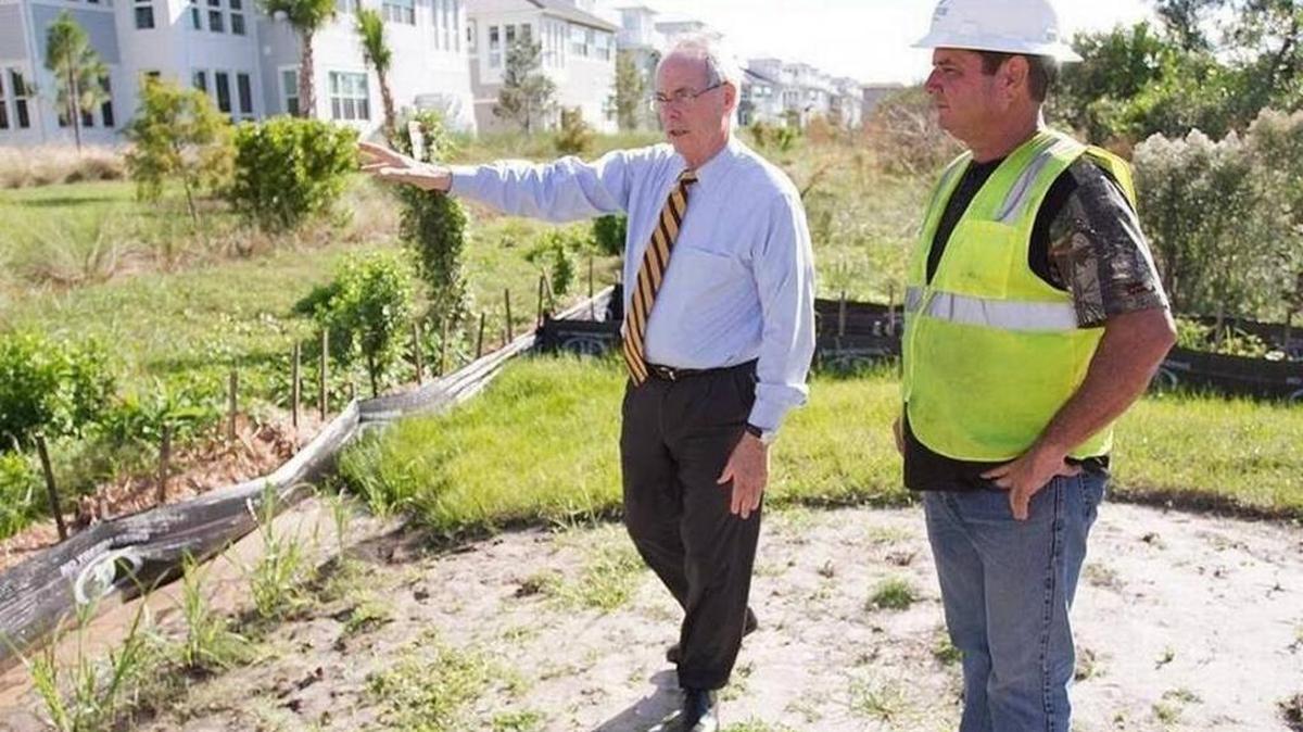 In this file photo, Pat Neal, chairman of Neal Communities, looks over preparations being made at his Harbor Sound development with a superintendent for E.T. MacKenzie.