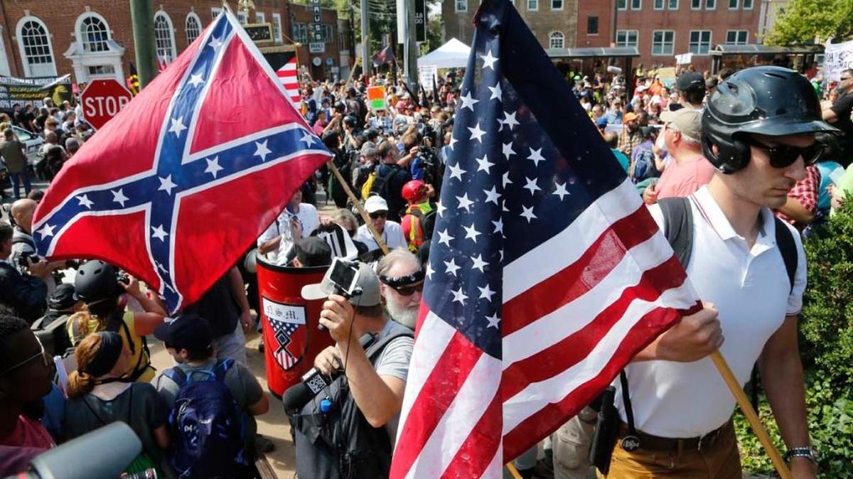 White nationalist demonstrators walk into Lee park surrounded by counter demonstrators in Charlottesville, Va., Saturday, Aug. 12, 2017.