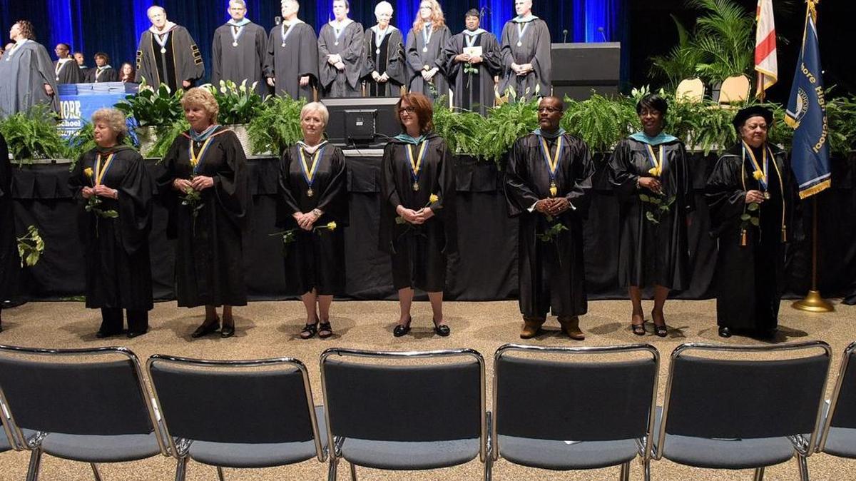 Former staff and teachers stand in front of the stage at the Bayshore High School graduation ceremony held at the Bradenton Area Convention Center Friday night.