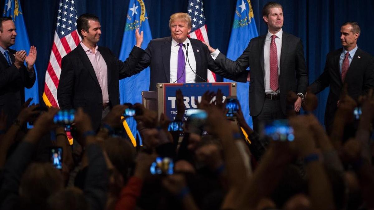Donald Trump, center, speaks during a campaign event in Las Vegas on Feb. 23, 2016, the day of the Nevada Republican caucuses. Sons Donald Trump Jr., left, and Eric, right, embrace their father on stage.