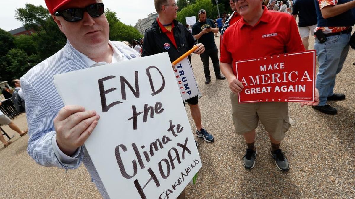 Protesters hold signs during a rally to support President Donald Trump, Saturday, June 3, 2017, in Washington.