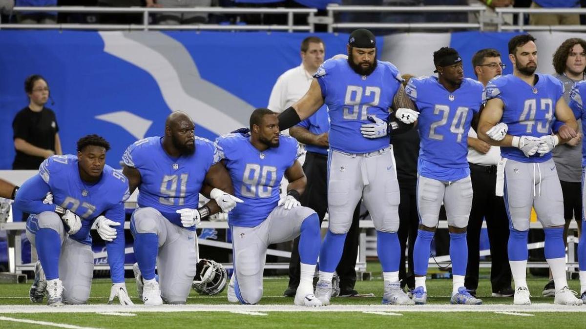 In a file photo from Sept. 24, 2017, Detroit Lions defensive end Armonty Bryant (97), defensive tackle A'Shawn Robinson (91) and defensive end Cornelius Washington (90) take a knee during the national anthem before an NFL football game against the Atlanta Falcons, in Detroit. The sight of football players kneeling during the national anthem across the United States is the continuation of a tradition nearly as old the song itself.