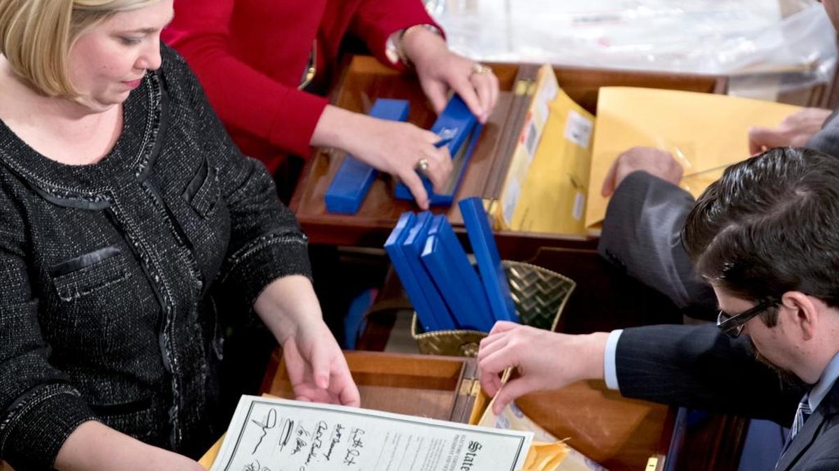In this Jan. 4, 2013 file photo, clerks unseal the certificates of results from all 50 states during a meeting of the U.S. Electoral College in the House of Representatives on Capitol in Washington. The Electoral College was devised at the Constitutional Convention in 1787. It was a compromise meant to strike a balance between those who wanted popular elections for president and those who wanted no public input.