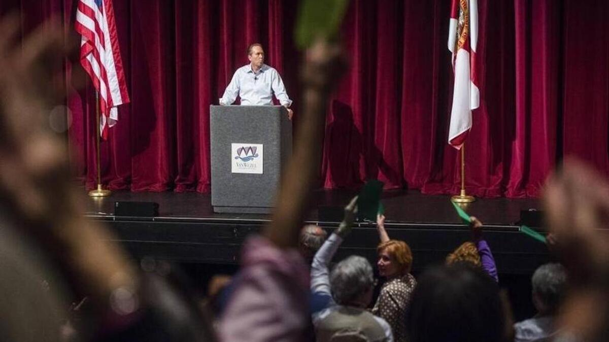 Constituents stand and become vocal in disagreement while Congressman Vern Buchanan answers questions as over 1,700 people gathered for a town hall meeting at the Van Wezel auditorium in Sarasota March 18.