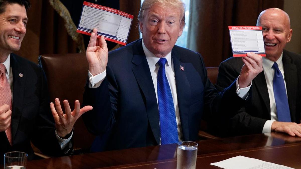 President Donald Trump holds an example of what a new tax form may look like during a meeting on tax policy with Republican lawmakers including House Speaker Paul Ryan of Wis., and Chairman of the House Ways and Means Committee Rep. Kevin Brady, R-Texas, right, Thursday in the Cabinet Room of the White House.