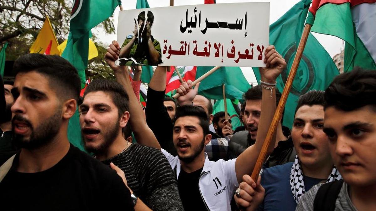 Protesters chant slogans Tuesday as they hold a placard with Arabic writing that reads: "Israel knows only the language of force," during a demonstration against U.S. President Donald Trump's decision to recognize Jerusalem as the capital of Israel, in front of the United Nations headquarters in Beirut, Lebanon.