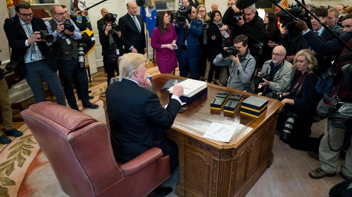 President Donald Trump gives a thumbs up after signing a sweeping tax bill in the Oval Office of the White House, Friday in Washington. Trump signed the bill on Friday that Republicans promise will benefit the middle class, despite warnings from Democrats that the new law could be harmful to the country.