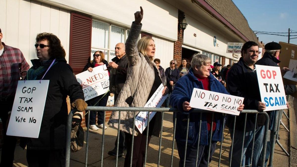 Demonstrators protest the Republican federal tax bill outside the office of Rep. Leonard Lance, R-N.J., in Westfield, N.J., Dec. 4, 2017.