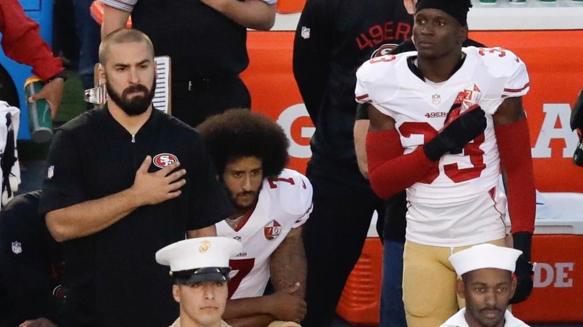 FILE - In this Thursday, Sept. 1, 2016 file photo, San Francisco 49ers quarterback Colin Kaepernick, middle, kneels during the national anthem before the team's NFL preseason football game against the San Diego Chargers, in San Diego. NFL Commissioner Roger Goodell disagrees with Kaepernick's choice to kneel during the national anthem, but recognizes the quarterback's right to protest.