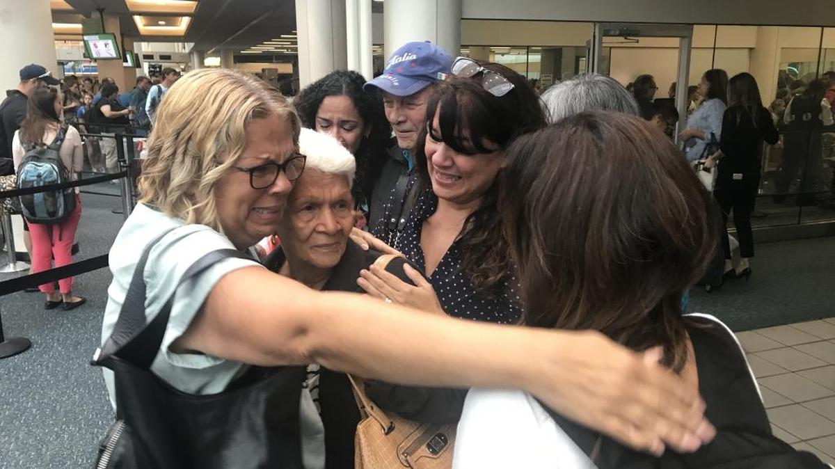 Leonor Figueroa, 82, center, a survivor of Hurricane Maria, is surrounded by her daughters after arriving Tuesday at the Orlando airport from Puerto Rico.