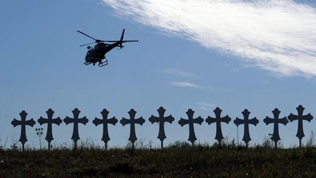 A law enforcement helicopter flies over crosses placed near the scene of a shooting at the First Baptist Church of Sutherland Springs, Monday, Nov. 6, 2017, in Sutherland Springs, Texas.