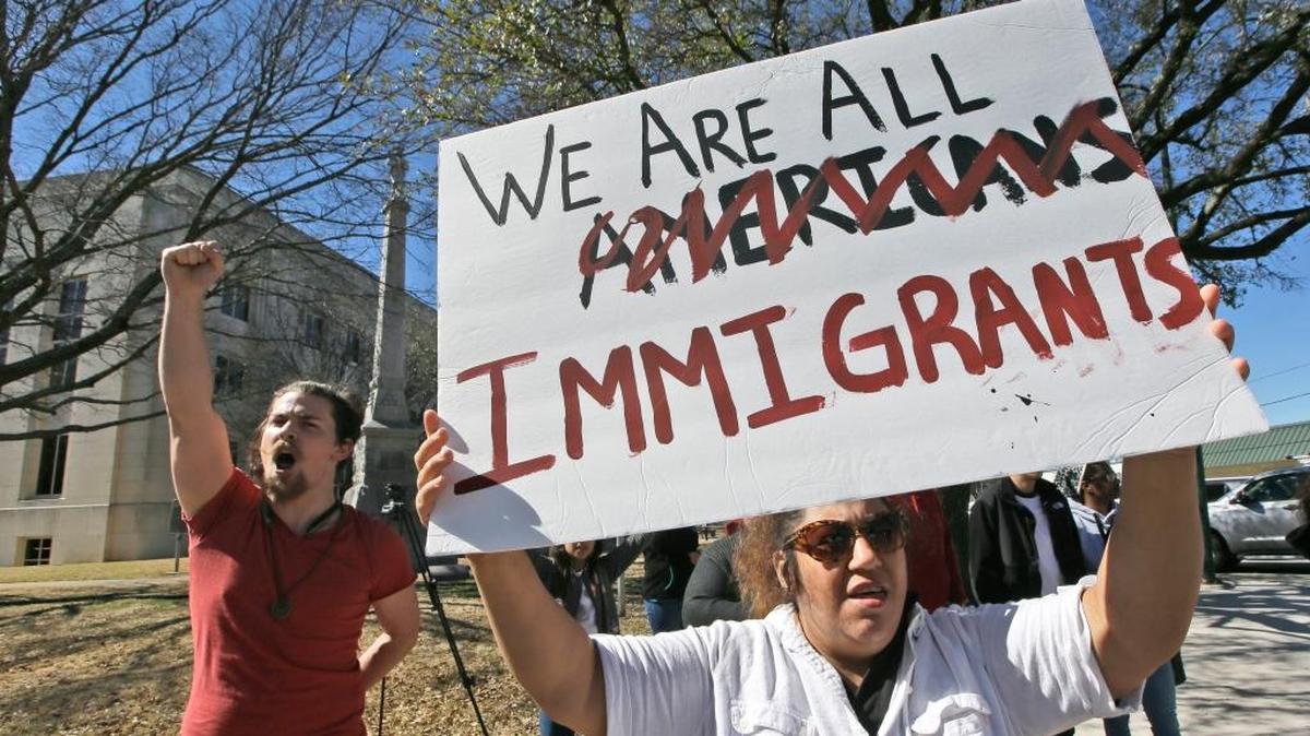 Protesters chant outside the Grayson County courthouse Thursday in downtown Sherman, Texas. In an action called "A Day Without Immigrants," immigrants across the country are expected to stay home from school, work and close businesses to show how critical they are to the U.S. economy and way of life.