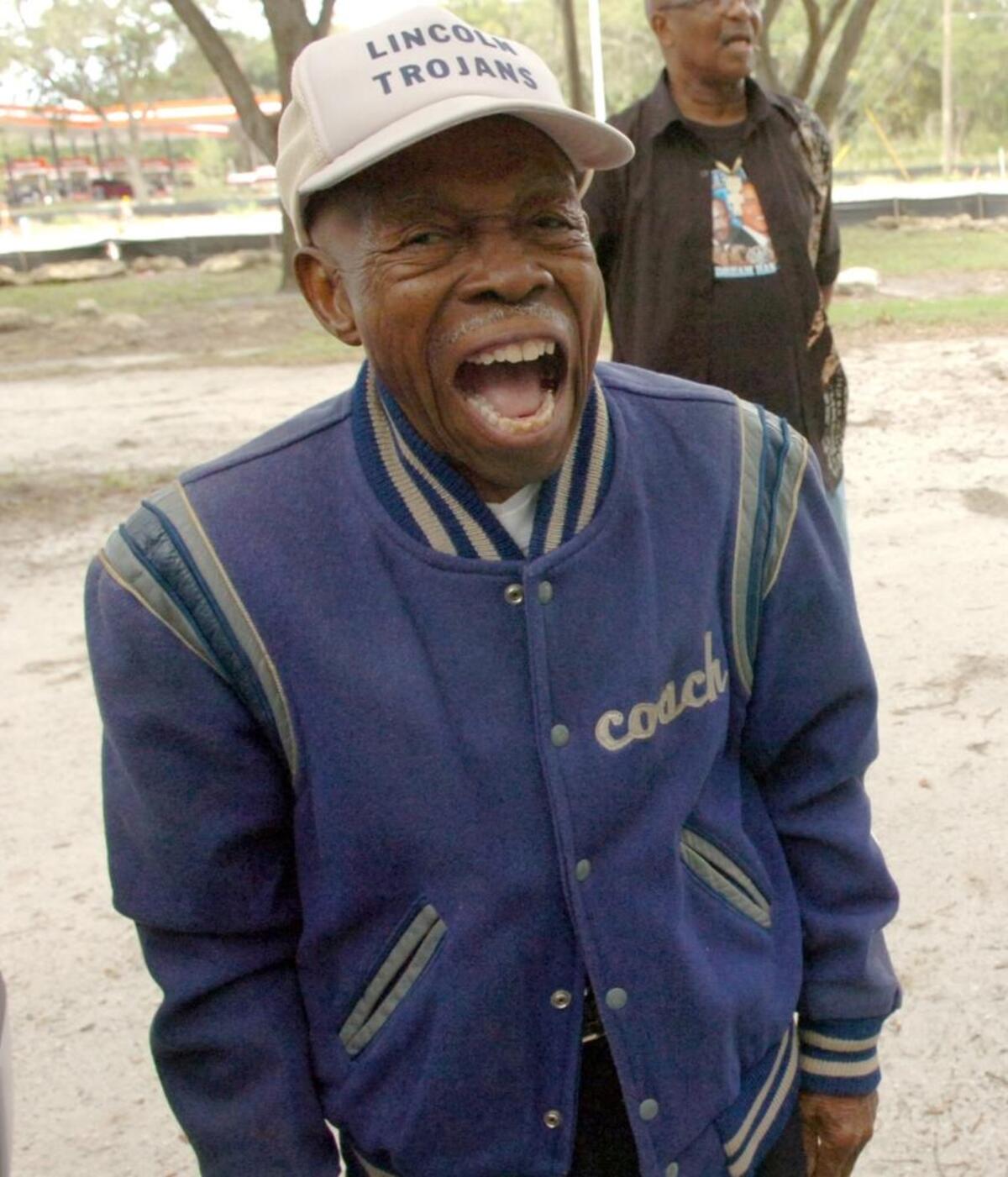 Not worn since 1968, Coach Eddie Shannon smiles as he tried on his Lincoln Trojans jacket.