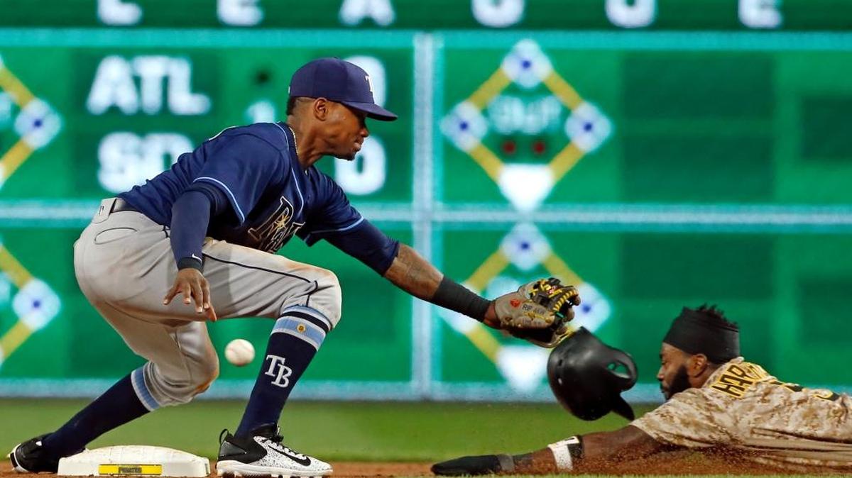 The throw from Tampa Bay Rays catcher Jesus Sucre gets away from shortstop Tim Beckham, left, as Pittsburgh Pirates’ Josh Harrison slides safely into second with a stolen base during the seventh inning of a baseball game in Pittsburgh on Thursday. The Pirates won 4-0.