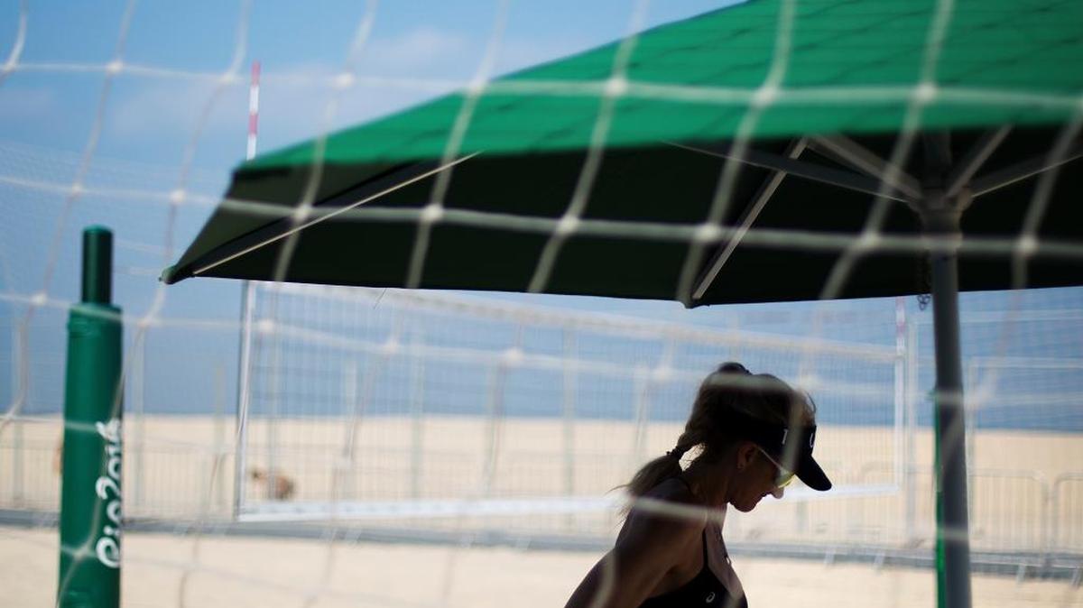 Beach volleyball player Kerri Walsh Jennings, of the United States, stands in the shade Tuesday after a practice session ahead of the 2016 Summer Olympics at the beach volleyball venue on Copacabana Beach in Rio de Janeiro, Brazil.