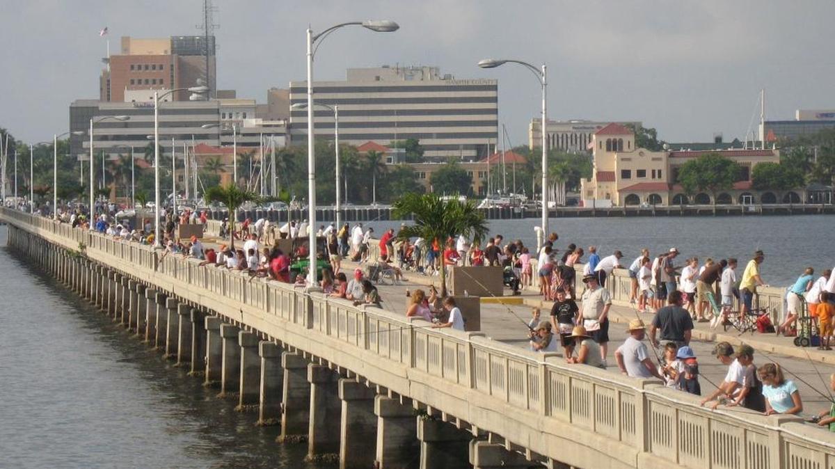 About 500 people, including more than 200 young anglers, line the Green Bridge fishing pier on for a kids fishing tournament. The tournament schedule