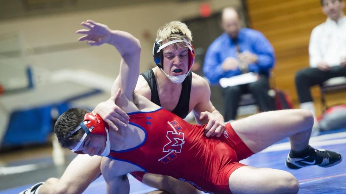 Palmetto’s Dominic Bass (rear), shown during the county meet on Feb. 11, won the district title in the 152-pound weight class on Saturday at Booker High School in Sarasota. He is one of 14 Tigers to advance to the regional tournament next weekend.