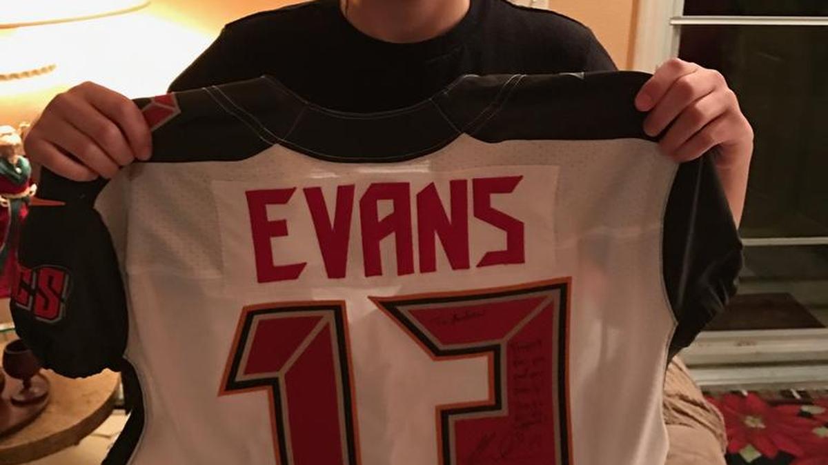 Andrew Wischer poses with the jersey Mike Evans signed for him