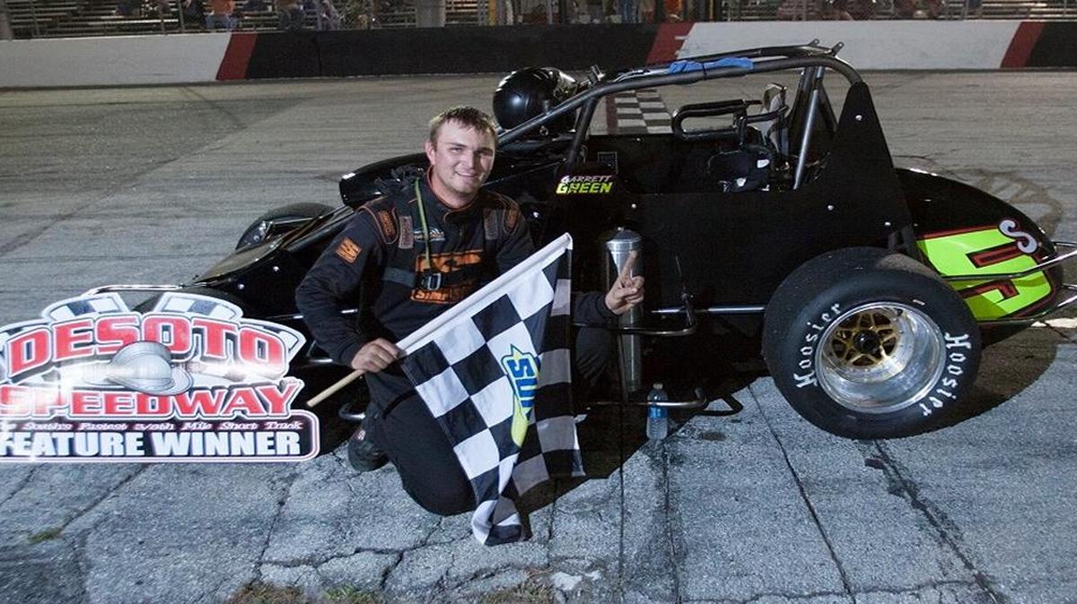 Garrett Green poses with the checkered flag after his victory in the 30-lap Paulie Milum Memorial American Drilling of Sarasota feature race.