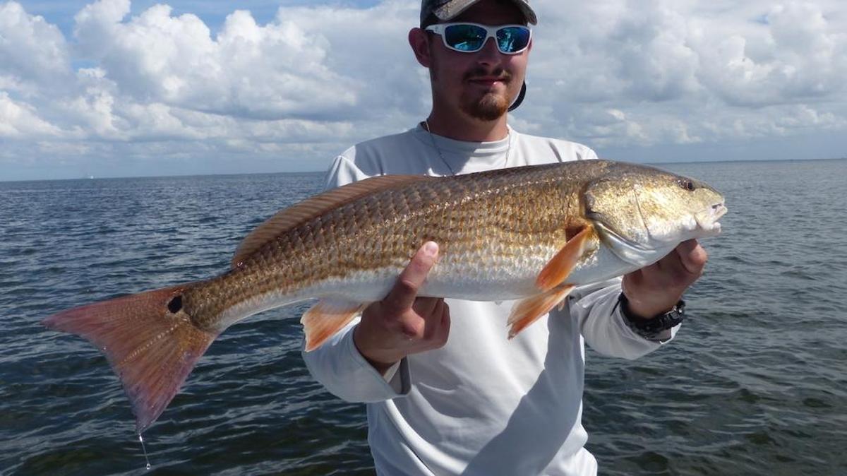 Aaron Minch holds the 27-inch redfish he caught Saturday during the first day of the two-day 19th annual Yerrid Foundation Grand Slam Fishing Tournament out of St. Petersburg on Saturday.