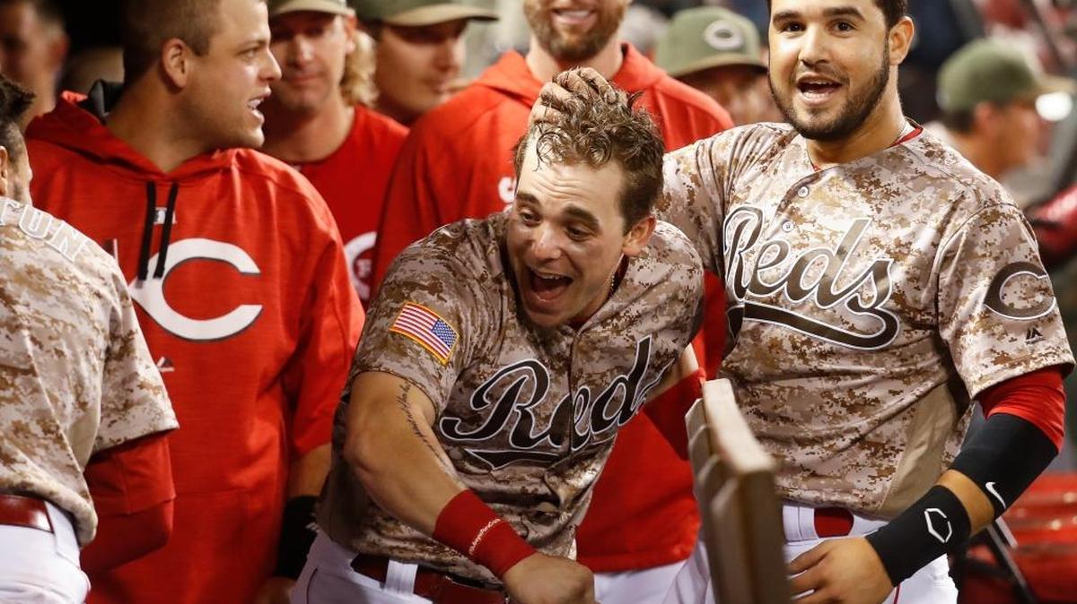 The Reds’ Scooter Gennett, center, celebrates in the dugout after hitting a two-run home run – his fourth of the game – during Tuesday’s 13-1 win against the Cardinals.