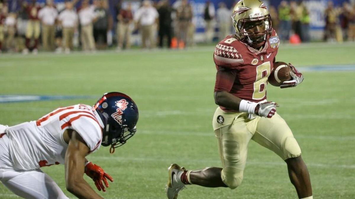 Florida State wide receiver Kermit Whitfield (8) runs past Mississippi defensive back Jaylon Jones on a 3-yard touchdown during the second half on Monday in Orlando.