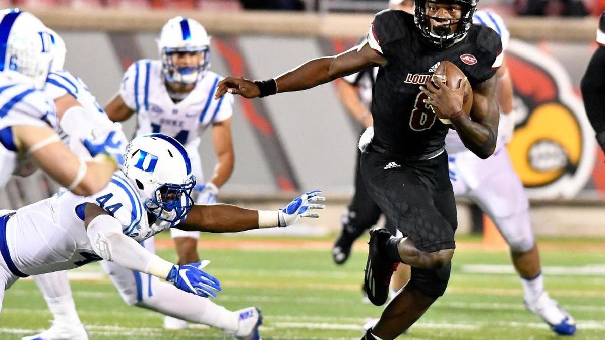 In this Oct. 14 file photo, Louisville quarterback Lamar Jackson (8) runs from the grasp of Duke linebacker Joe Giles-Harris (44) during the second half of an NCAA college football game, in Louisville, Ky. Lamar Jackson has all but wrapped up the Heisman Trophy award, but Oklahoma's Dede Westbrook is starting to get some attention
