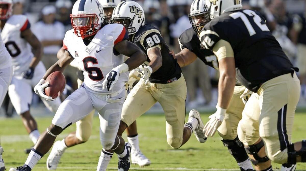 Connecticut cornerback Jhavon Williams runs with the ball past Central Florida wide receiver Tre’Quan Smith (80) and offensive lineman Tyler Hudanick (72) last season. Hudanick is one of four returning starters on the line this season.