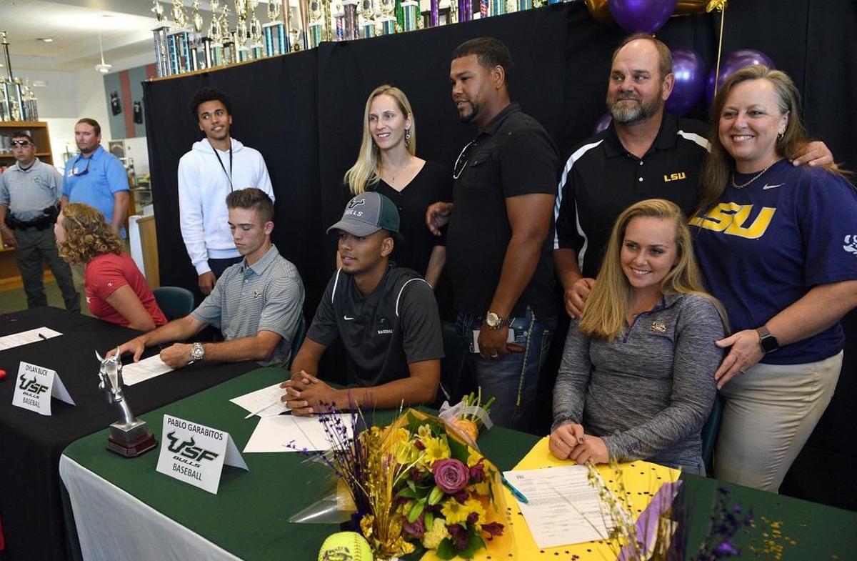 Friends and families pose with Lakewood Ranch athletes, from right, Morgan Cummins (LSU), Pablo Garabitas (USF), Dylan Buck (USF) and Haille Bogumil (Stony Brook) during Wednesday’s signing day ceremony.