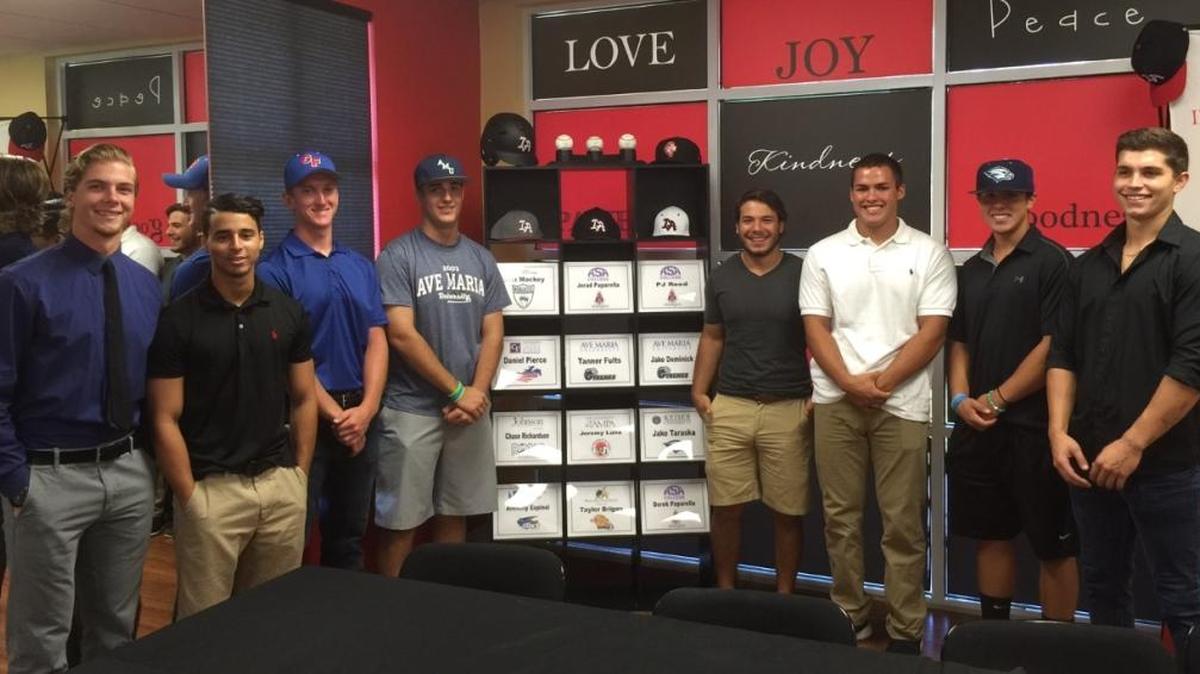 (From left) Taylor Briggs, Jeremy Luna, Daniel Pierce, Tanner Fults, Jerad Paparella, Matthew Mackey, Jake Taraska and Jake Dominick pose with placards and hats from their college signing ceremony