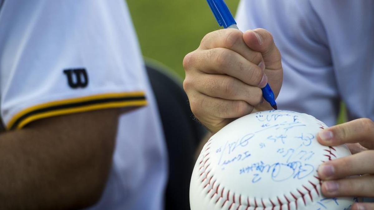 Marauders players sign oversize baseballs for fans during a preseason event. The Marauders return home on Tuesday for a series against Dunedin.
