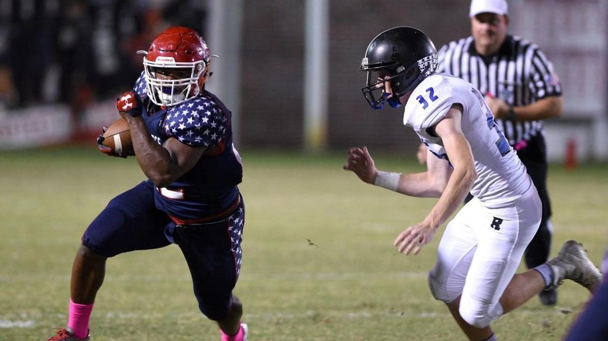 Manatee’s Josh Booker outruns Riverview’s Taylor Vap during Friday night’s victory. Booker rushed for 114 yards on 22 carries as the Hurricanes improved to 4-2.
