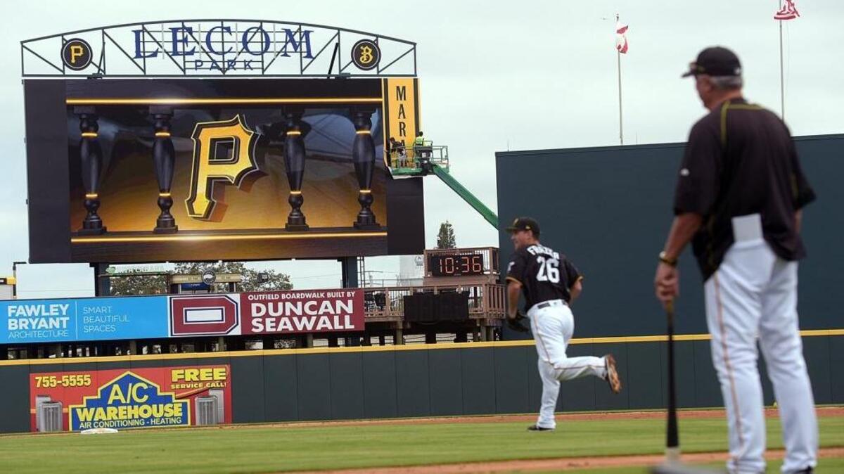 Players practice on the field with the new video display in the background for the Pirate's Spring Training season opener at LECOM Park Saturday.