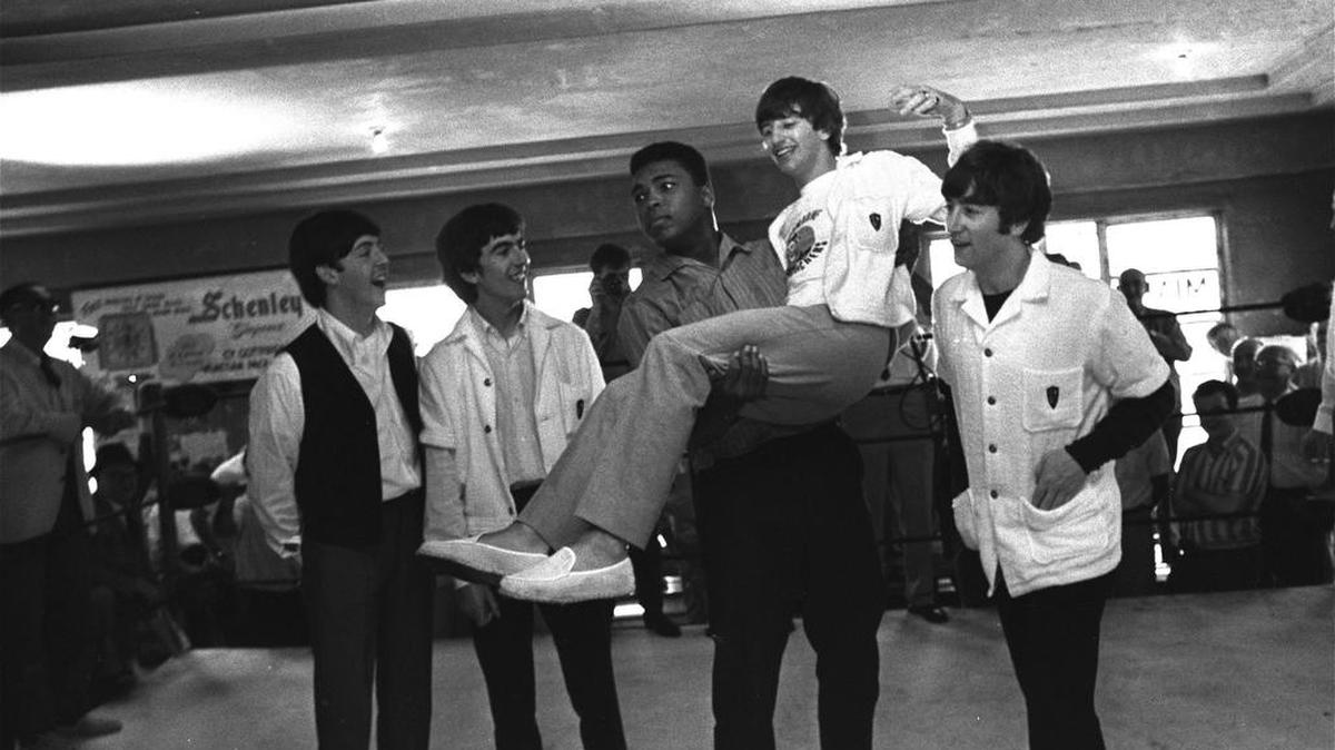 In this Feb. 18, 1964 file photo, boxer Cassius Clay (Muhammad Ali) lifts Ringo Starr, one of the Beatles, into the air while the singers visited Clay's camp in Miami Beach. Others are, from left: Paul McCartney, George Harrison, and John Lennon.