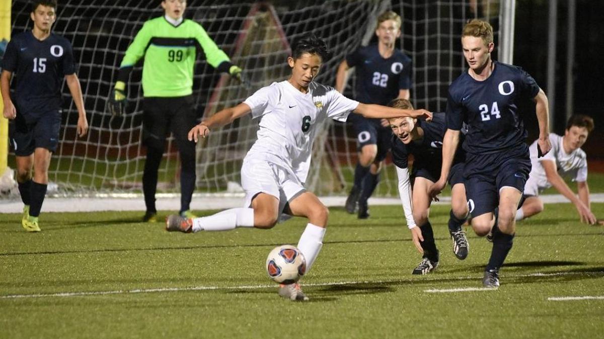 Saint Stephen’s Dan Li passes away from the Out-of-Door Academy defense during Friday’s Class 1A-District 7 boys soccer final at Saint Stepehen’s. The hosts won 3-1.