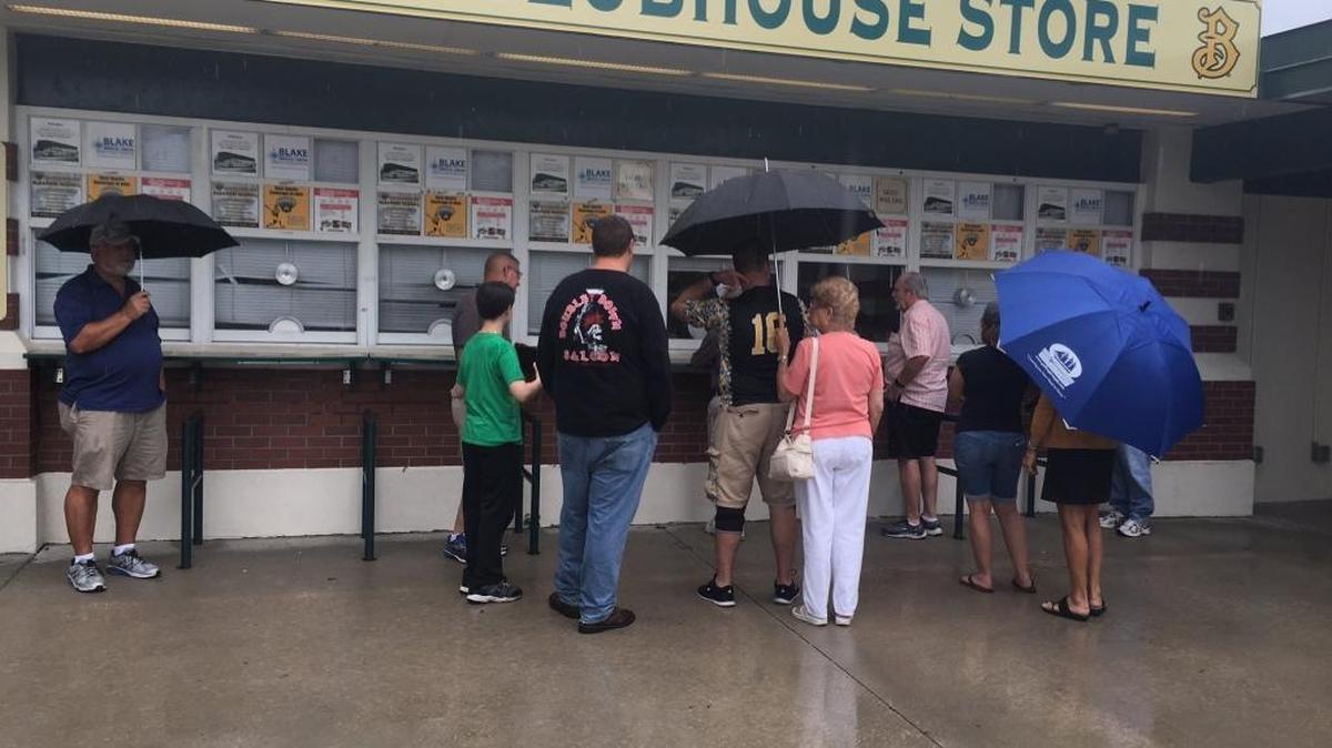 Fans wait in the rain at the ticket office before a game in early June. The Marauders’ last game before the all-star break was delayed more than a half hour by Thursday’s afternoon storm, but the game was played. The Marauders lost.