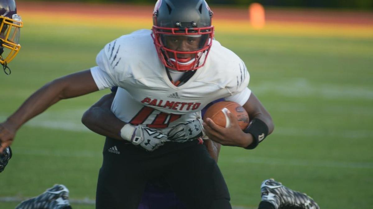Palmetto’s Jason Spicer Jr. tries to shake loose from a tackle during a preseason game against Sarasota Booker on Friday.