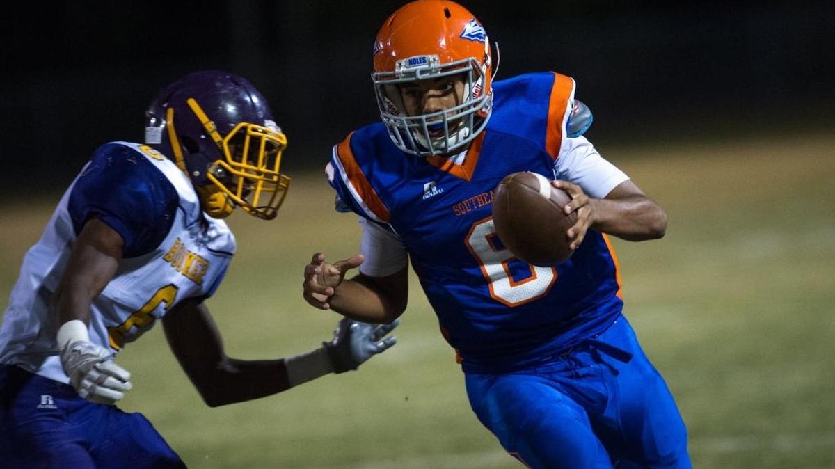 Southeast’s quarterback Alex Taylor pushes past Booker’s Jonas Ziegler as Southeast High School faces off against Booker High School on Friday.