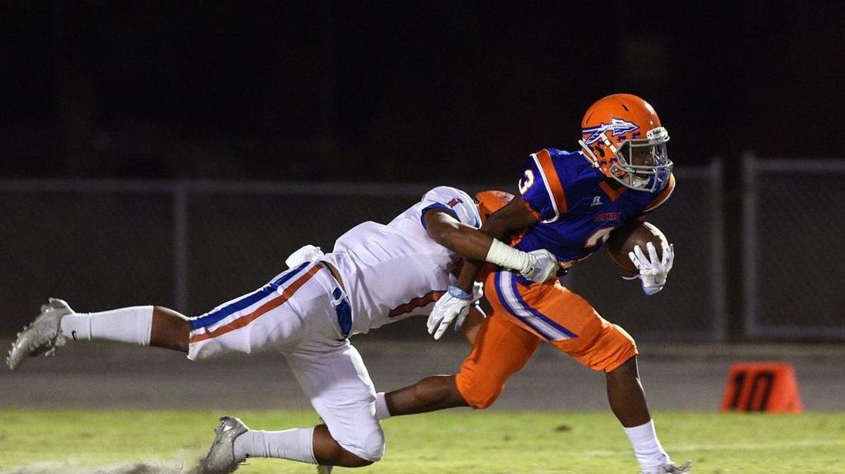 Hardee's Sherry Lee tries to stop Southeast's Tyler Stevenson at Southeast's Paul Maechtle Field at John Kiker Memorial Stadium Friday night.