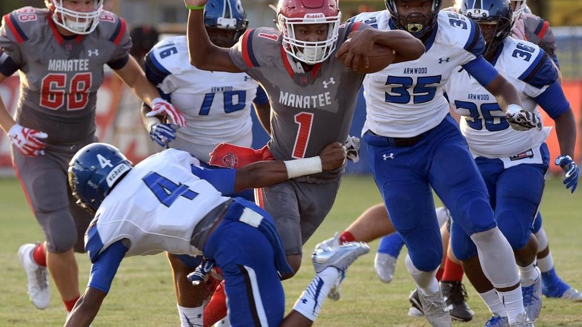 Manatee's Tarique Milton evades Armwood High's players in Friday night's pre-season game against Armwood High at Hawkins Stadium.