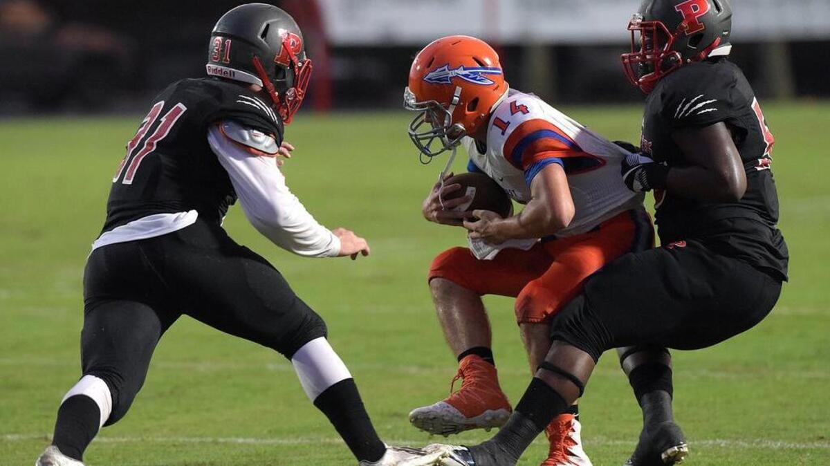 Palmetto's Andrew Duncan and Noah Artis try to stop Southeast's Tristin Hernandez at Palmetto's Harlee Stadium Friday night.