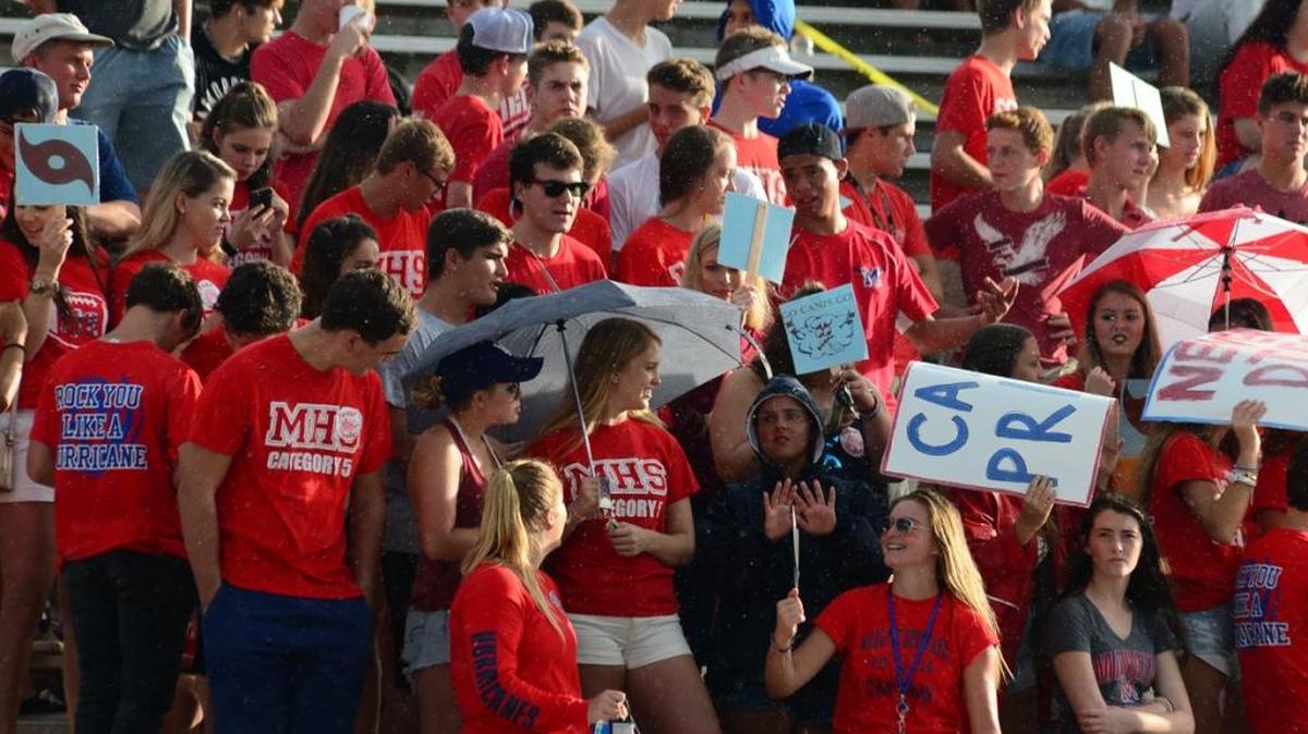 Manatee students try to keep dry during the Hurricanes previously rescheduled game against Palmetto. Hurricane Hermine forced the game between the Canes and Tigers to be postponed last month.