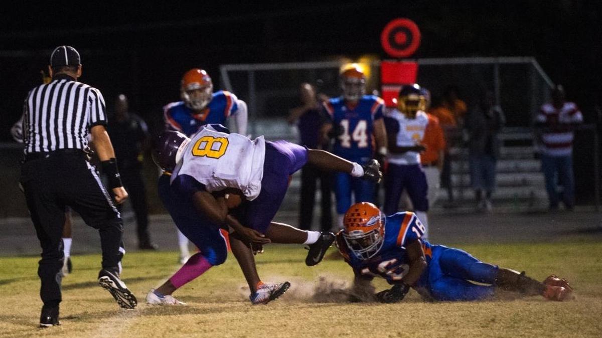 Booker’s Jamal Benson pushes past Southeast defenders for the first touchdown of Friday’s game at Southeast High School in Bradenton.