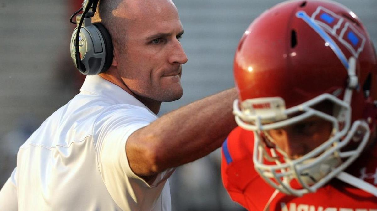 Manatee High coach John Booth pats a player on the back after a score during their first preseason game against Largo at Kinnan Field at Hawkins Stadium.