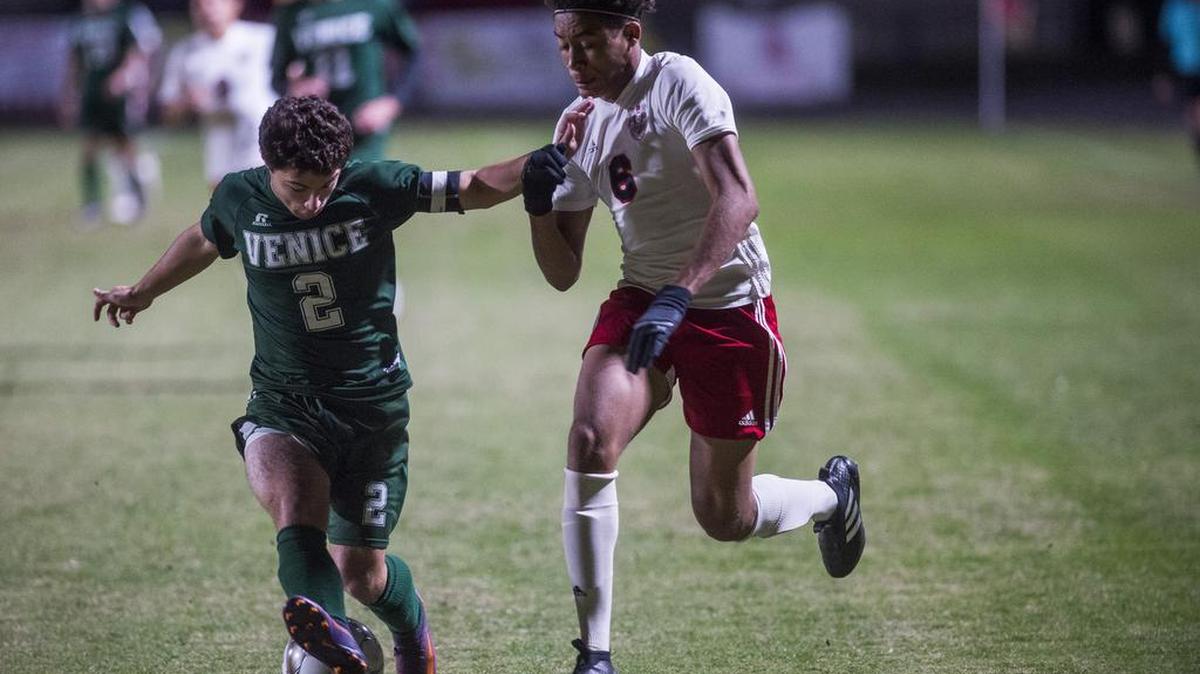Palmetto’s Ty Dolan battles Venice’s Javier Diaz for the ball during Friday’s district final at Palmetto High School.