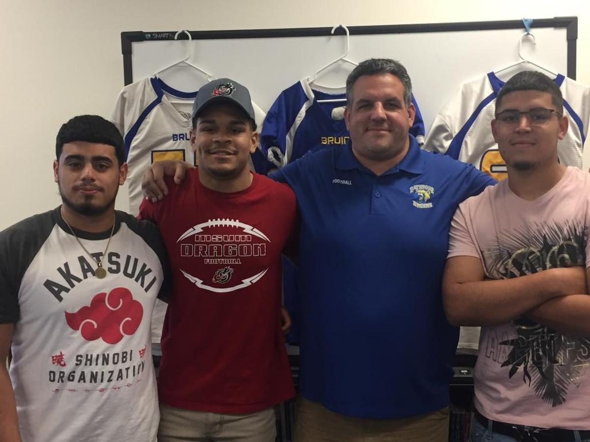 Bayshore signed football players for the first time in four years on Wednesday. From left to right: Jassiel Velez, Michael Franks, head coach John Biezuns and Edwin Crespo.
