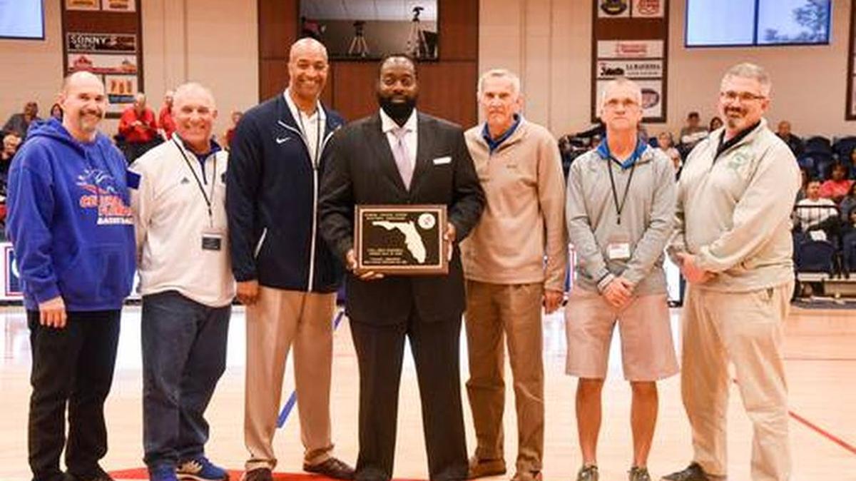 Stanley Cromartie (center) holds his Florida junior college Hall of Fame plaque.